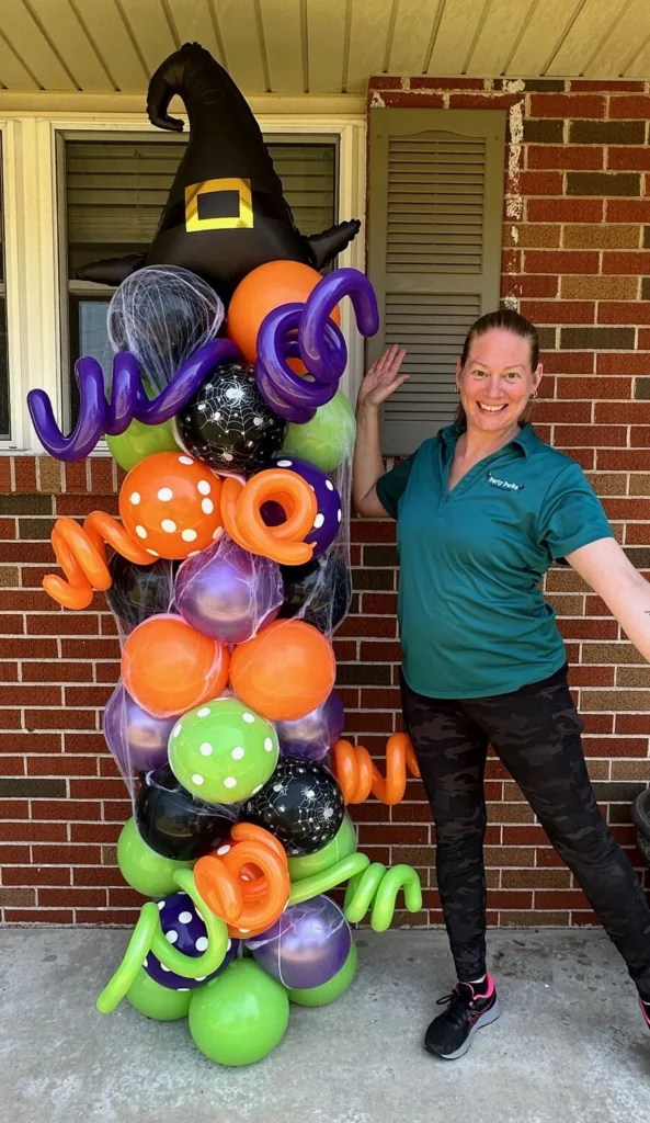 Whimsical Halloween balloon tower in St. Charles with polka dots, curls, and a witch hat topper, designed by Party Perks.