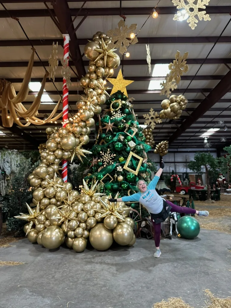 Elegant gold balloon garland and star accents wrapping around a Christmas tree — luxe winter balloon décor by Party Perks STL