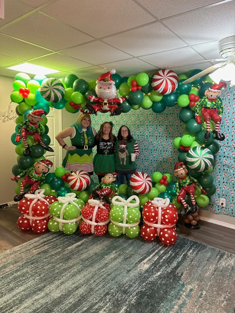 Santa’s Workshop balloon photo frame with elves, peppermints, and balloon presents — playful holiday décor by Party Perks STL in St. Charles.