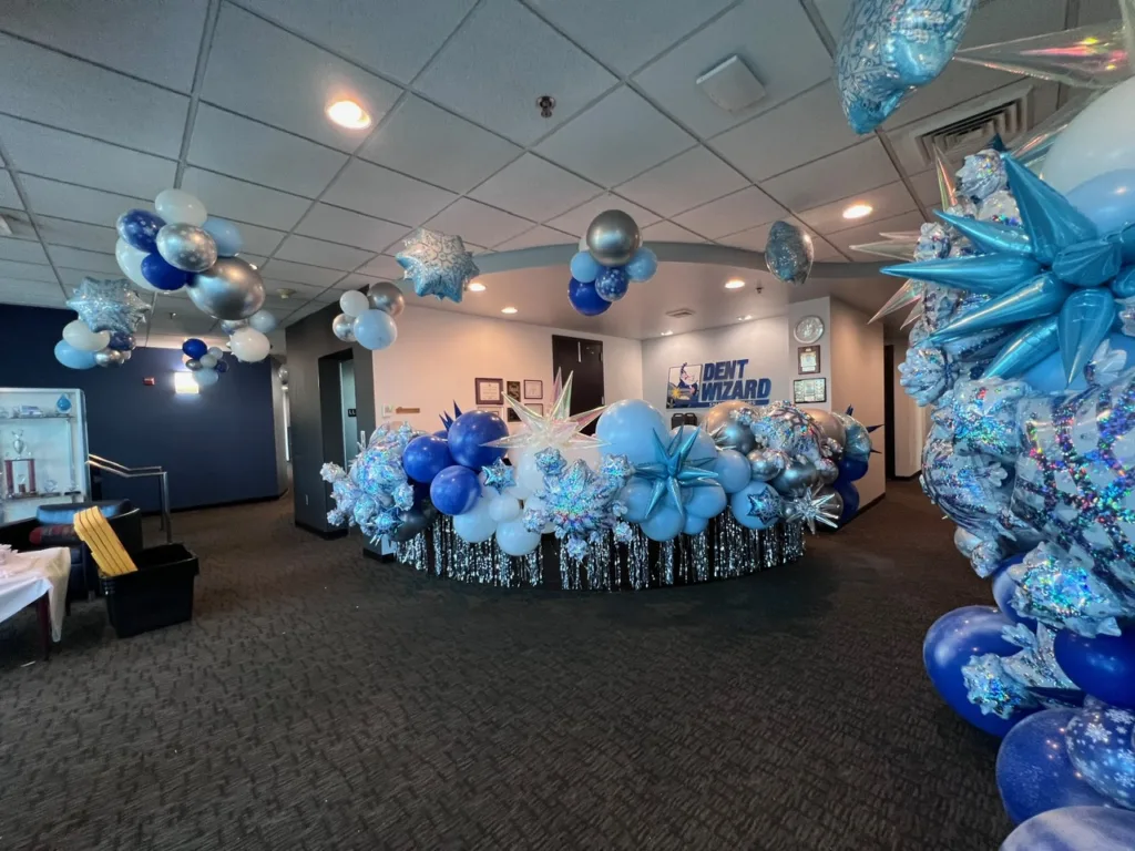 Winter Wonderland corporate lobby balloon décor in silver, blue, and white — elegant balloon design by Party Perks STL for Dent Wizard.