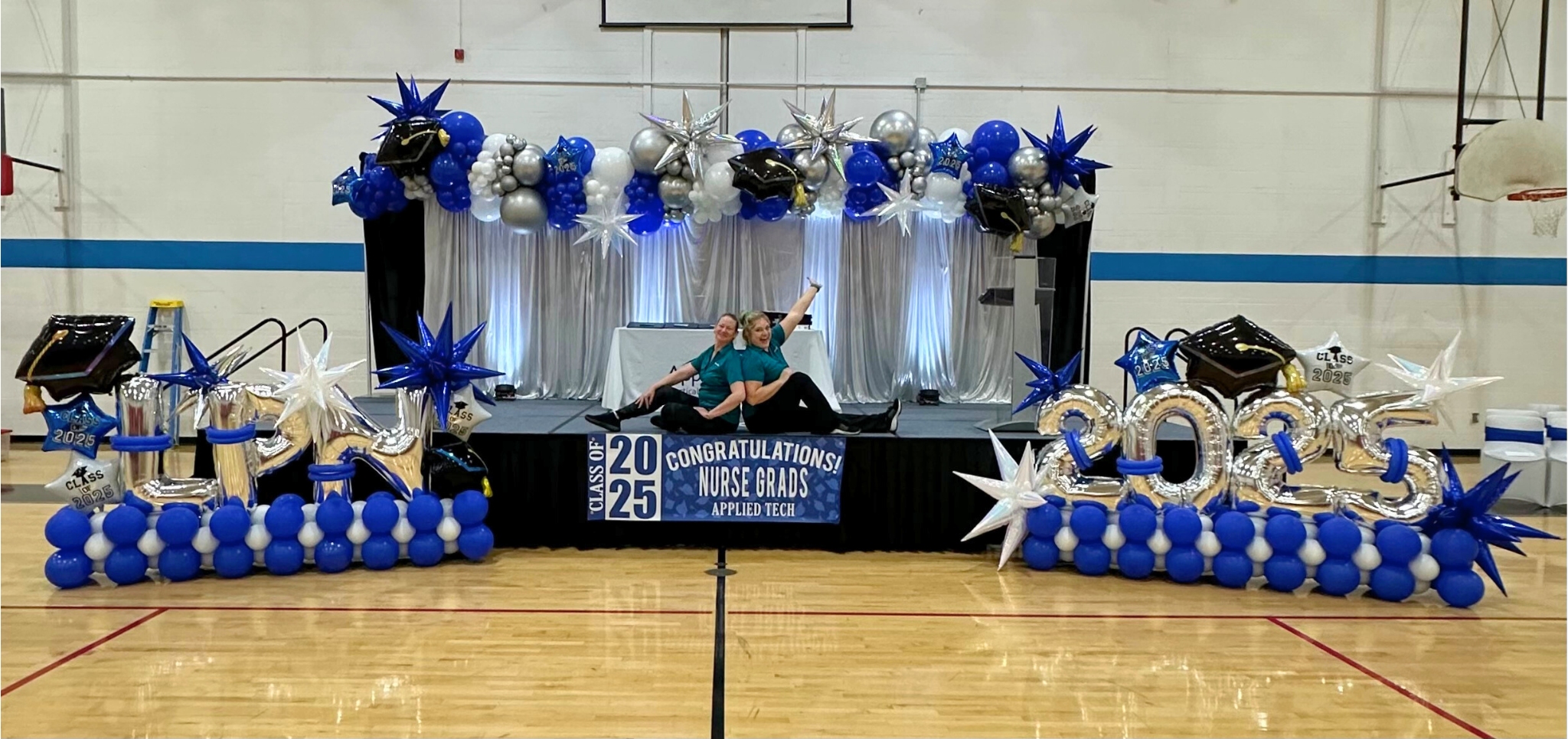 2025 LPN Graduation Stage Graduation balloon decor in St. Louis featuring custom blue and silver balloon stage installation with Class of 2025 balloon numbers and nurse graduation backdrop.