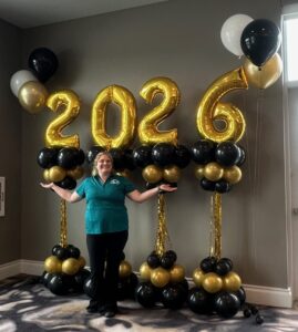 Graduation decor in St. Louis featuring gold 2026 balloon numbers mounted on black and gold balloon columns.