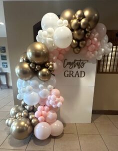 Luxury graduation balloon backdrop in St. Louis with “Congrats Grad” chiara wall and custom white, blush, and gold balloon styling.