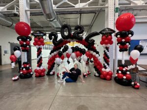 Graduation balloon arch and columns in St. Louis featuring red, black, and white decor with 2024 number balloons for school ceremony entrance.