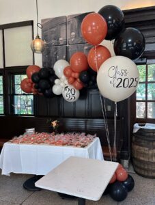 Class of 2025 graduation balloon decor in St. Louis with organic balloon garland and helium balloon bouquet for party celebration.