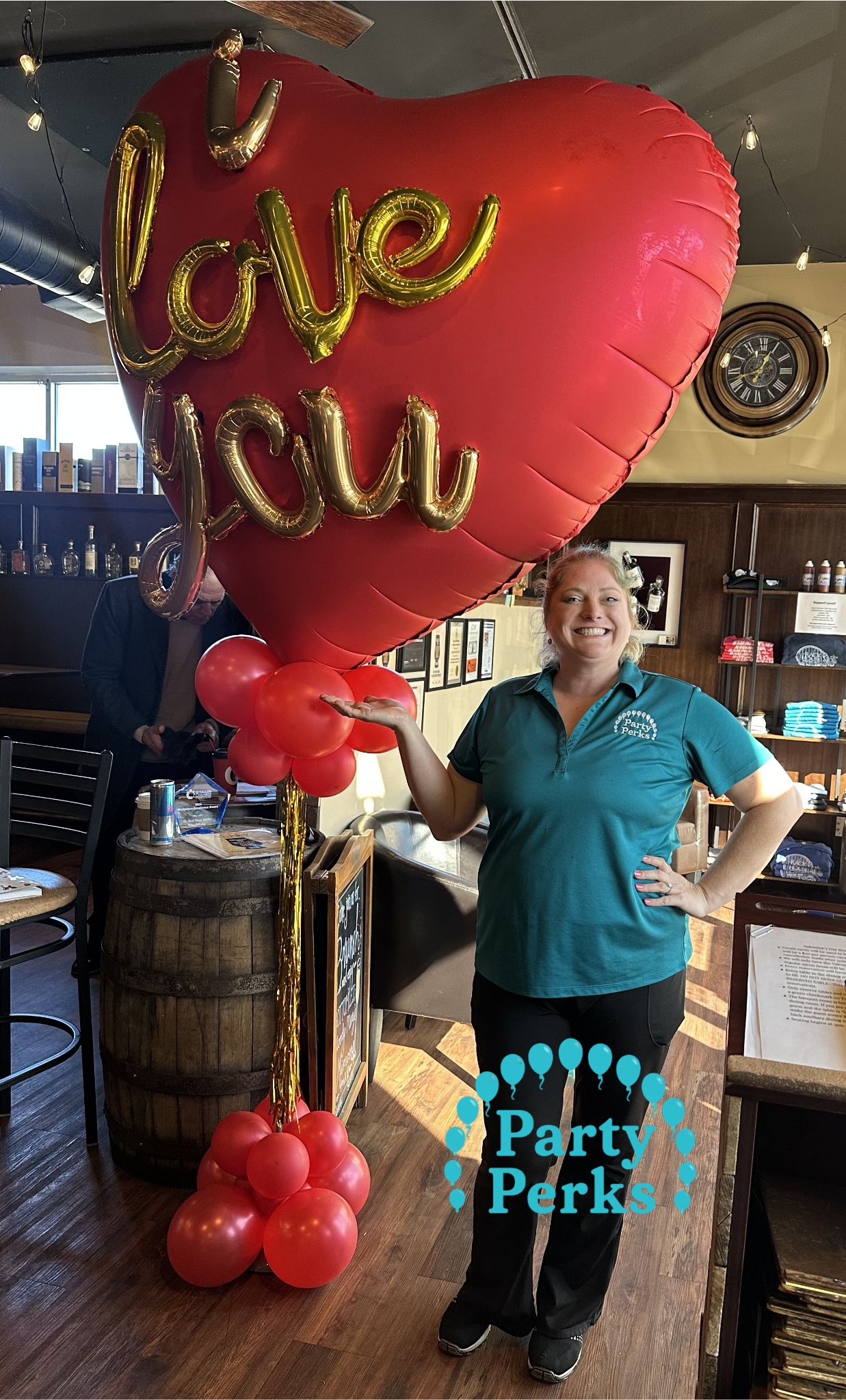 Luxury balloon styling by Party Perks featuring a giant red heart balloon with gold “I love you” lettering on a balloon base display for a Valentine’s celebration at The Rack house kitchen wine whiskey
