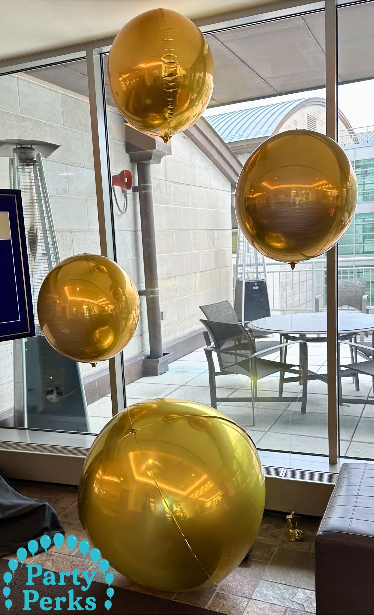 mardi-gras-balloon-decorations-st-louis-2 Gold balloon decorations arranged near windows for a Mardi Gras event in the St. Louis area creating festive themed event décor.