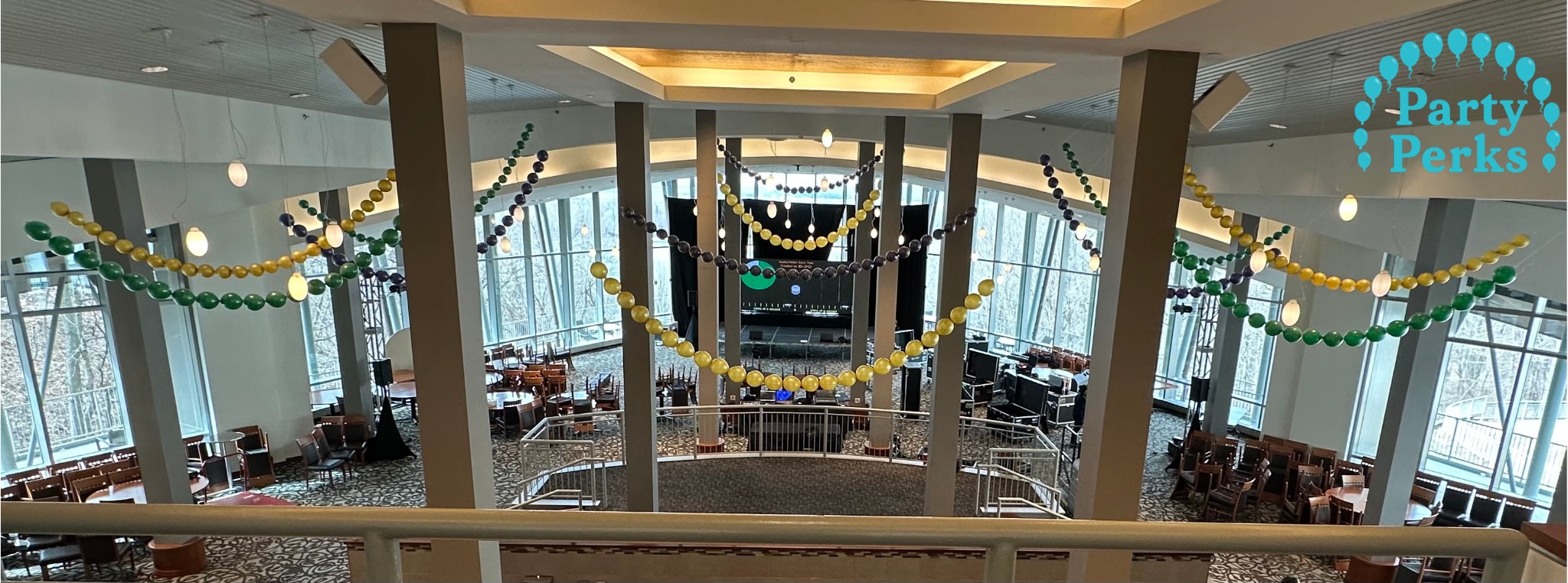 mardi-gras-party-balloon-decorations-st-louis w logo Mardi Gras balloon decorations in purple, green, and gold hanging across a large event venue in the St. Louis area.